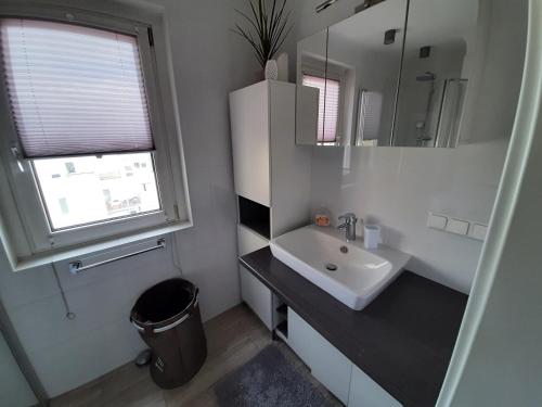 a white bathroom with a sink and a mirror at Brilliant View: Balcony Home, Modern, Stylish and newly Renovated in Vienna