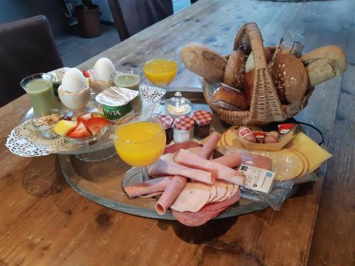 een tafel met een dienblad met ontbijtproducten en -dranken bij B&B de Vrijheid en de Ruimte in Steenbergen in Steenbergen
