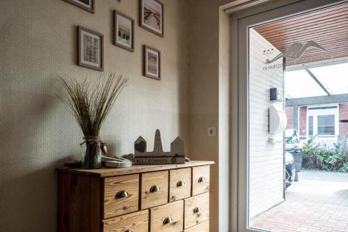 a dresser with a vase on it next to a door at Garni Hotel & Appartements Nordstrand in Nordstrand