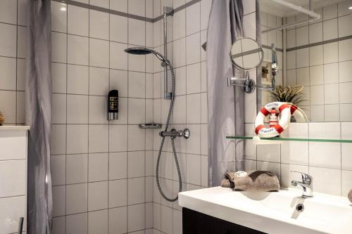 a bathroom with a shower and a sink at Garni Hotel & Appartements Nordstrand in Nordstrand