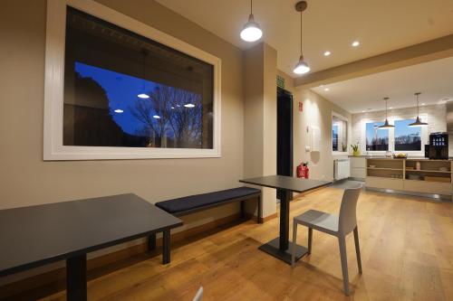 a dining room with two tables and a kitchen at Larrion Hostal - Ostatua in Larrión