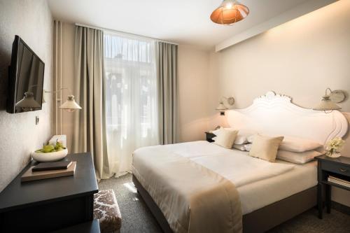 Habitación de hotel con cama grande y TV en Hotel Lungomare Opatija - Liburnia, en Opatija