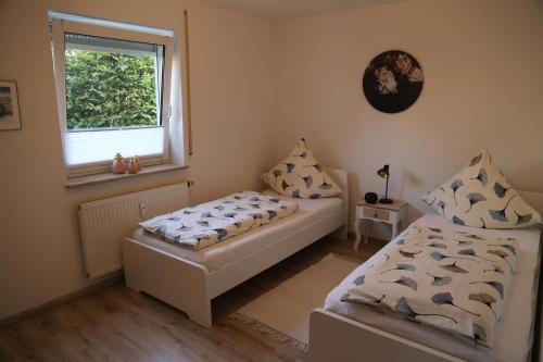 1 dormitorio con 2 camas y ventana en FeWo "Regnitztraum" in Forchheim - 3-Zimmer-Apartment - 2 Schlafzimmer en Forchheim
