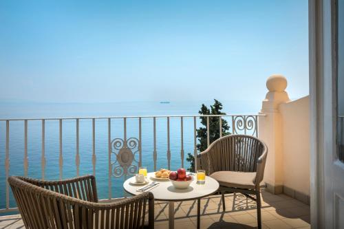 a table with a bowl of fruit on a balcony at Hotel Lungomare Opatija - Liburnia in Opatija