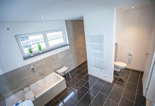 uma casa de banho com uma banheira, um WC e um lavatório. em Apartment Haus Maria Waldblick em Burtenbach