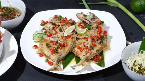 a white plate with three pieces of food on it at Ayani Hotel Banda Aceh in Banda Aceh