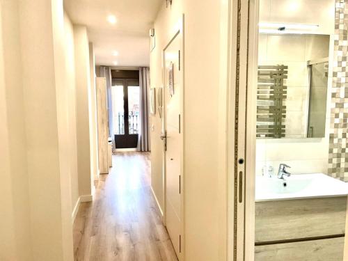 a hallway of a bathroom with a sink and a mirror at Apartamentos Aranda - Ribera in Aranda de Duero
