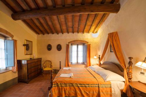 a bedroom with a bed and a dresser and windows at Forte Di Tregognano in Subbiano