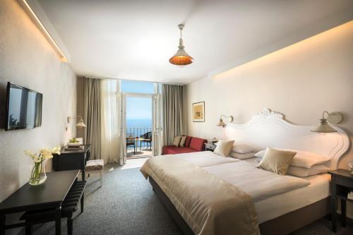 a hotel room with a large bed and a desk at Hotel Lungomare Opatija - Liburnia in Opatija