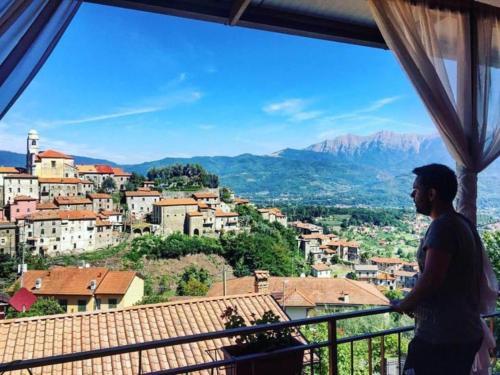 a man standing on a balcony looking out at a city at Hotel Ristorante El Caracol in Mulazzo