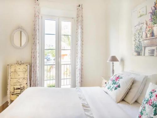 una camera bianca con un letto e una finestra di Sitges Spaces Beach House-4 bedrooms, 3 Bathrooms, Large Terrace, Jacuzzi, Center-Beach a Sitges