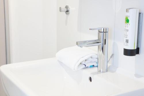 a bathroom sink with a faucet and a towel at Landhaus Nordhelle Garni in Meinerzhagen