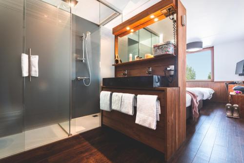 a bathroom with a shower and a sink and a mirror at Alpine Hotel by SnowWorld in Landgraaf