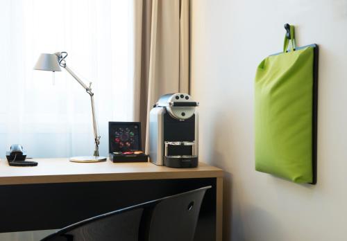 a desk with a coffee maker and a green bag at Thon Hotel Bergen Airport in Bergen