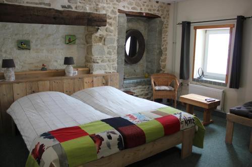 a bedroom with a bed with a colorful blanket on it at Maison le Barrage in Saint-Gervais-dʼAuvergne