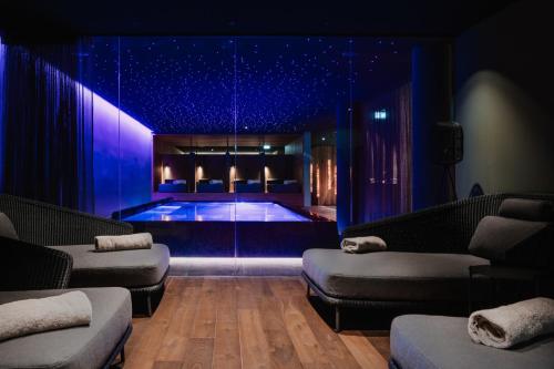 uma piscina num quarto com iluminação azul em Berghotel Biberkopf em Warth