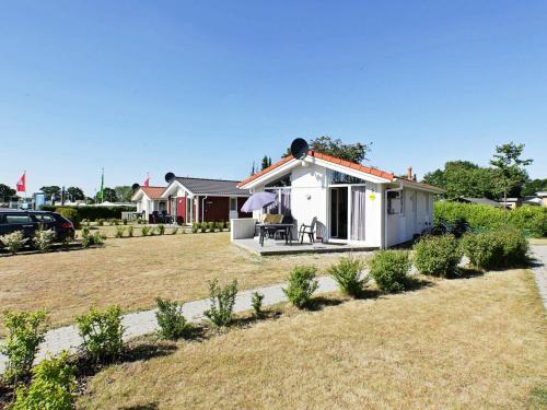 a small white house in a yard at 4 person holiday home in GROEMITZ in Grömitz