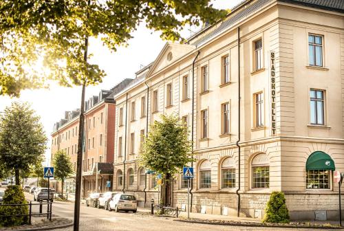 カトリーネホルムにあるBest Western Hotel Statt Katrineholmの通りに面した建物とその前に駐車された車