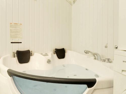 a white bathroom with a bath tub in it at 8 person holiday home in Hemmet in Hemmet