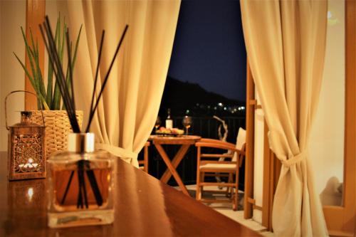 una mesa con un jarrón junto a una ventana en LAGADA HOLIDAY ROOMS en Lagkáda