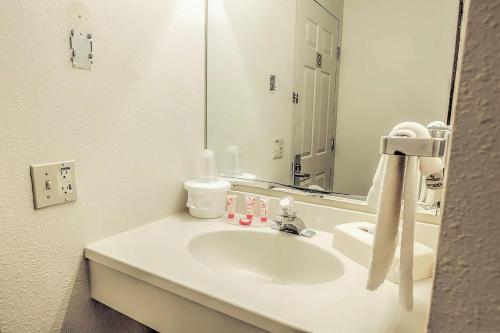 y baño con lavabo blanco y espejo. en Coratel Inn & Suites by Jasper McCook, en McCook