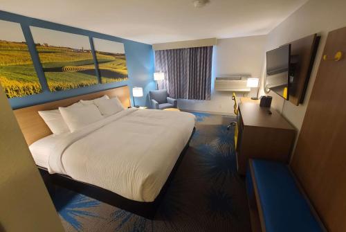 a hotel room with a bed and a desk and a television at Days Inn by Wyndham Johnson Creek in Johnson Creek