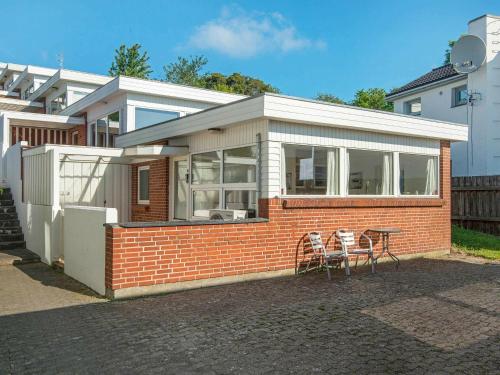 a brick house with two chairs and a table at 3 person holiday home in Gråsten-By Traum in Rønsheved