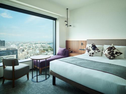 a hotel room with a bed and a large window at Mitsui Garden Hotel Toyosu Premier - Tokyo in Tokyo