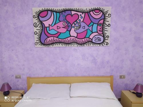 1 dormitorio con 1 cama con pared morada en Elena's Maison, en Solanas