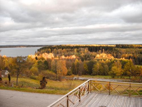 a wooden bridge with a view of a lake and trees at Hotell Paradis in Eksjö