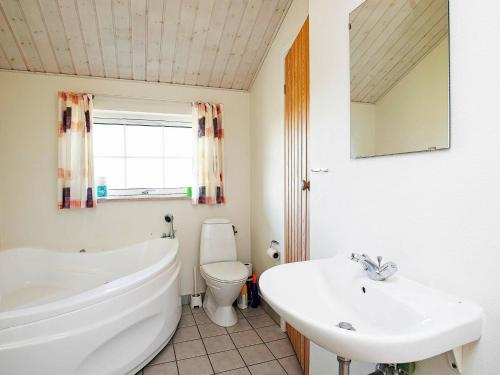 łazienka z wanną, toaletą i umywalką w obiekcie 7 person holiday home in L kken w mieście Løkken