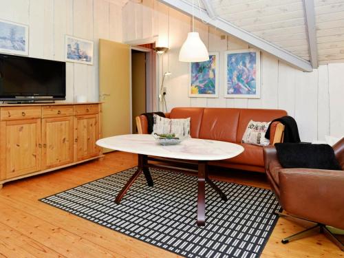 een woonkamer met een bank en een tafel bij 4 person holiday home in Oksb l in Oksbøl