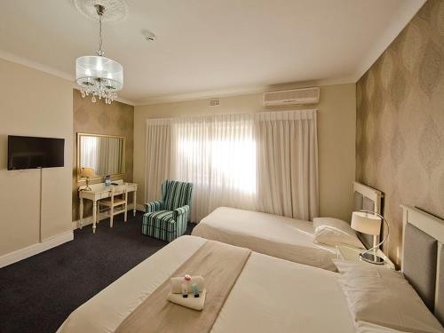 克尼斯納的住宿－拉塞爾酒店，酒店客房配有两张床和一张书桌