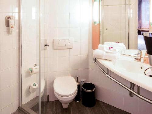 uma casa de banho com um WC e um lavatório em Ibis Poznan Stare Miasto em Poznań