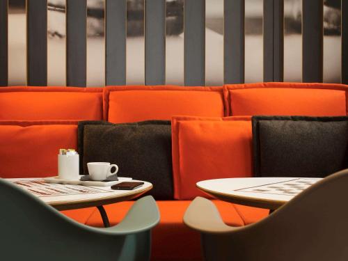 a couple of tables and chairs with coffee cups on them at ibis London Excel-Docklands in London