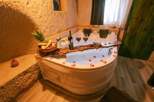 y baño con bañera y copas de vino. en Mia Cappadocia Cave Hotel, en Göreme