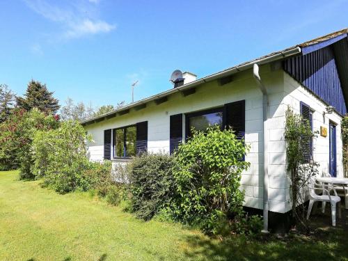 een wit huis met een tafel en stoelen in een tuin bij 6 person holiday home in Sp ttrup in Spottrup