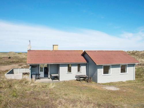 a small white house with a red roof on a hill at 6 person holiday home in Henne in Henne Strand