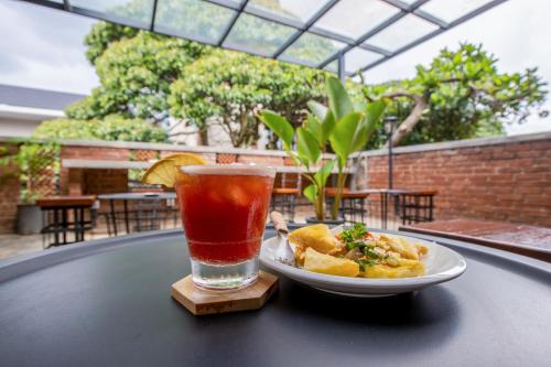 a plate of food and a drink on a table at Sekararum Butik Syariah Guesthouse in Bandung