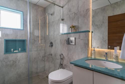 a bathroom with a shower and a toilet and a sink at Skyla Serviced Apartments & Suites Jubilee Hills in Hyderabad