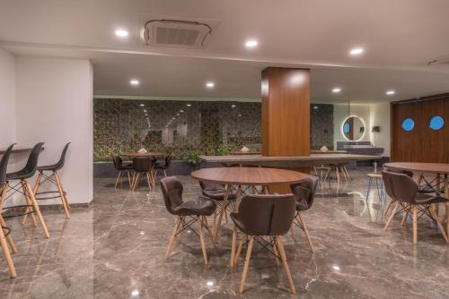 een restaurant met tafels en stoelen in een kamer bij SKYLA Studios & Suites - Jubilee Hills in Hyderabad