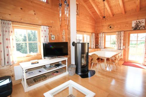 a living room with a television and a table with chairs at Chalet Königsleiten 168 in Königsleiten