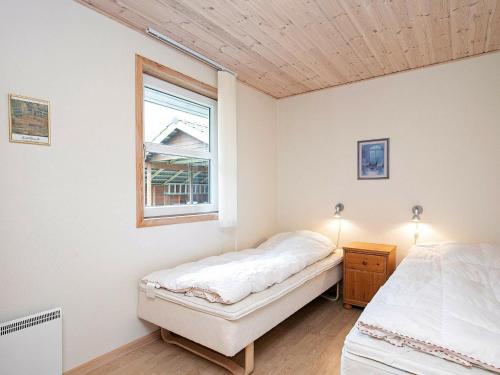 1 dormitorio con 2 camas y ventana en Holiday home Læsø XXIV, en Læsø