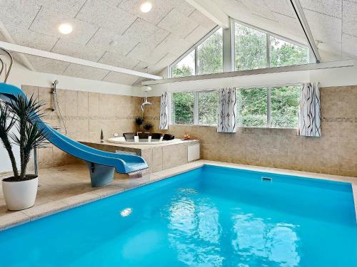 a bathroom with a blue swimming pool and a slide at 16 person holiday home in Dronningm lle in Gilleleje