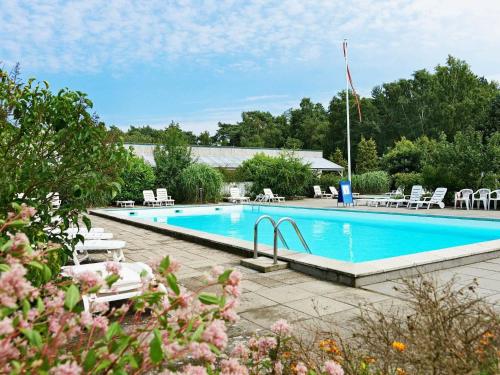 a large swimming pool with chairs at 4 person holiday home in Nex in Strandby Gårde