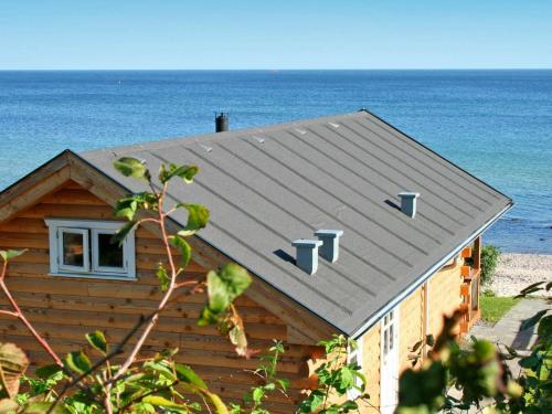 アリンエにある6 person holiday home in Allingeの海の背後にあるビーチの家