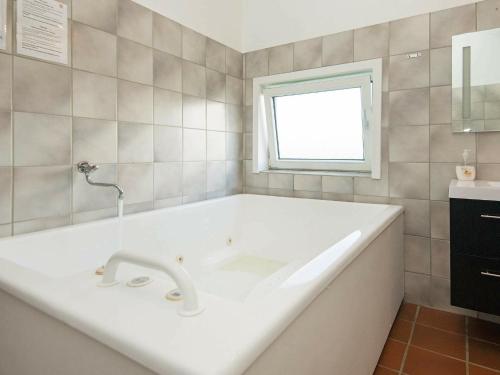 a white bath tub in a bathroom with a window at 8 person holiday home in Vejers Strand in Vejers Strand