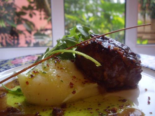 a plate of food with meat and potatoes on a table at Hotel Manolo Mayo in Los Palacios y Villafranca