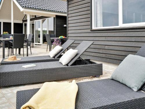 a group of chairs and tables on a patio at 20 person holiday home in Nørre Nebel in Nørre Nebel