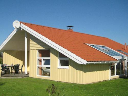 a house with an orange roof with a patio at 12 person holiday home in Otterndorf in Otterndorf
